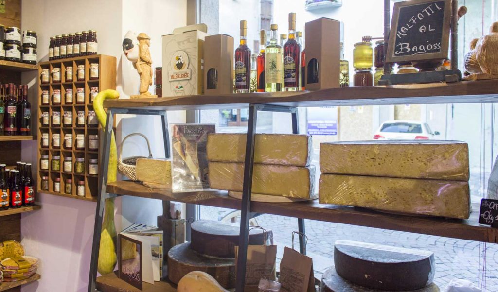 Fromage Bagoss présenté sur les étagères avec d'autres produits typiques de Bagolino