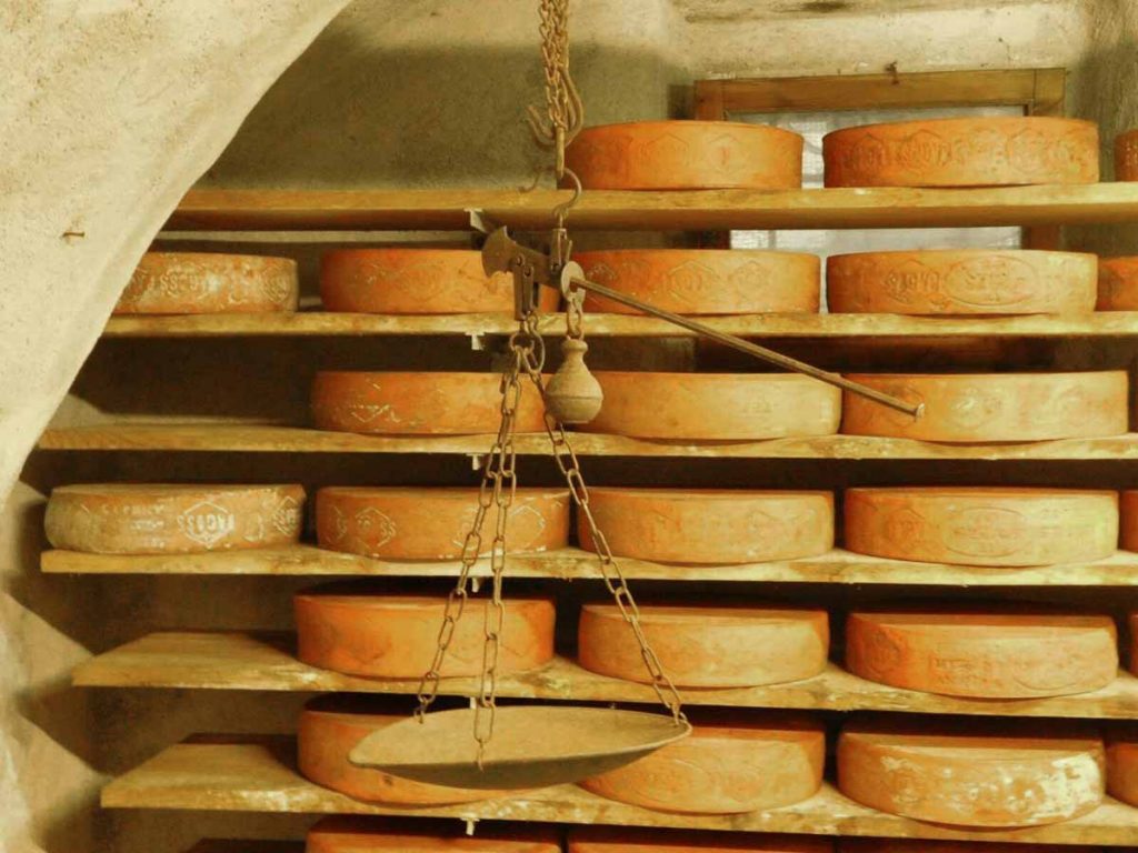 Moules à fromage Bagoss dans la cave de Bagolino avec des balances anciennes