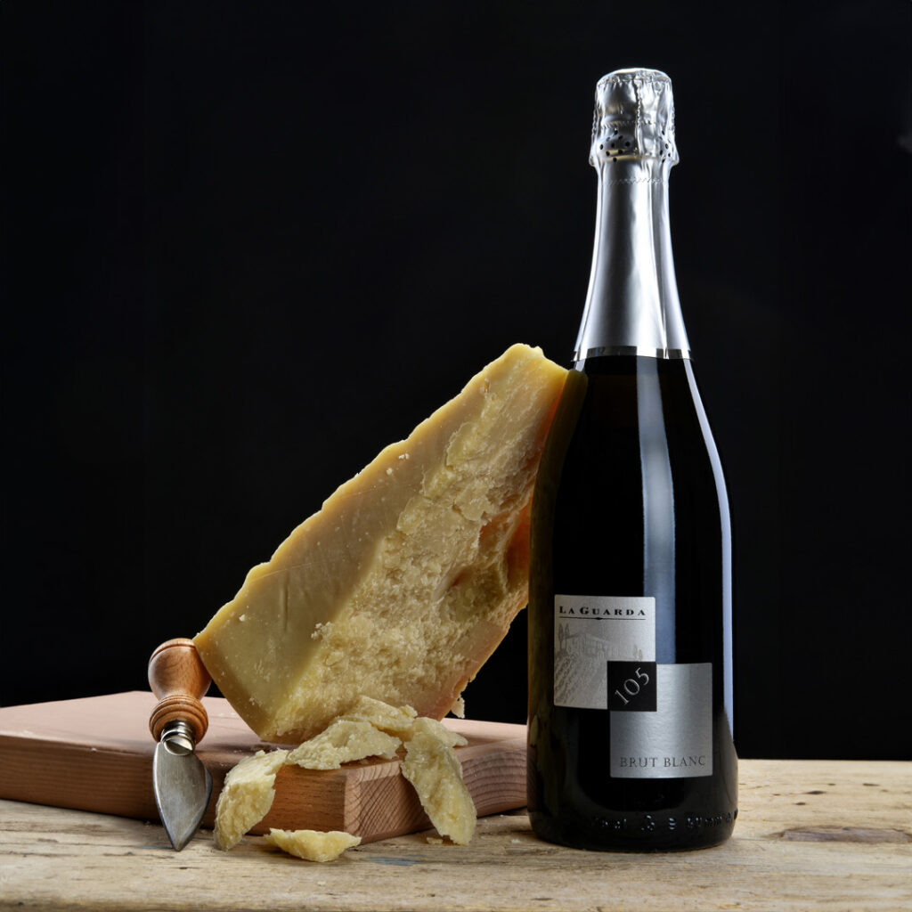 Bouteille de brut 105 blanc avec une tranche de fromage sur une planche à découper
